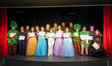 Tarsus Belediyesi Şehir Tiyatrosu tarafından gerçekleştirilen Yaratıcı Drama Oyun Çıkarma Atölyesi, üç aylık eğitim sürecinin ardından sahnelenen “Kırmızı Bantlı Kız” adlı tiyatro oyunu ile tamamlandı. Çocukların sahnelediği oyun, izleyicilerden büyük beğeni topladı.  Haftanın belirli günlerinde düzenli olarak yaratıcı drama eğitimi alan çocuklar; süreç boyunca özgüven kazanma, birlikte üretme, empati kurma ve ekip ruhunu deneyimleme fırsatı buldu. Yoğun prova sürecinin ardından sahneye çıkan çocuklar, başarılı performanslarıyla dikkat çekti.  Masal kahramanlarının eğlenceli bir balosunda geçen oyunda, kendini farklı hissettiği için dışlandığını düşünen Kırmızı Bantlı Kız’ın hikâyesi üzerinden; farklılıklara saygı, empati kurma ve hataları fark ederek telafi etmenin önemi vurgulandı. Dostluk ve anlayış mesajı veren oyun, seyirciler tarafından uzun süre alkışlandı.  Gösteri sonunda çocuklara katılım belgeleri takdim edildi. Tarsus Belediyesi, çocukların sanatsal ve kişisel gelişimlerine katkı sunan yaratıcı drama eğitimlerini sürdürmeye ve yeni gruplarla daha fazla çocuğu sanatla buluşturmaya devam edecek.